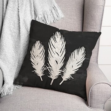 black pillow with white feathers in grey chair